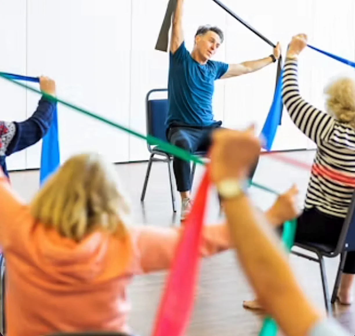 Class members stretching with colorful resistance bands