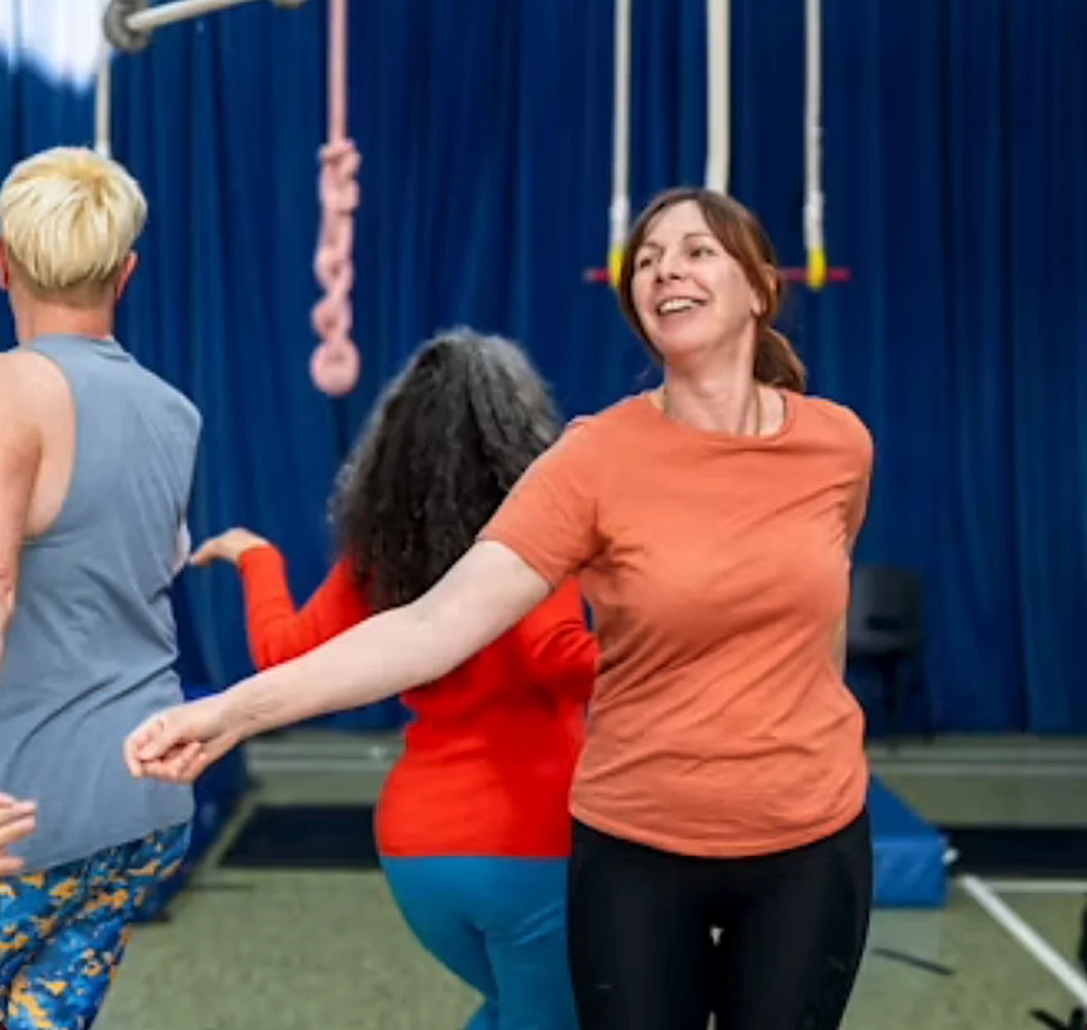 Smiling class members dancing together in a studio